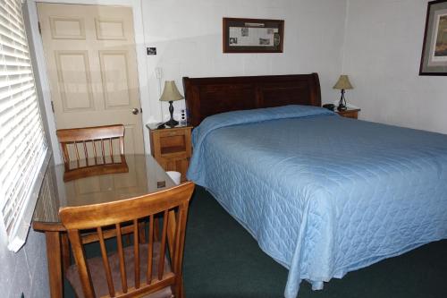 a bedroom with a bed and a chair at Big Meadow Lodge in Bridgeport