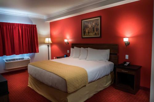 a hotel room with a large bed with red walls at Skyline Hotel and Casino in Las Vegas