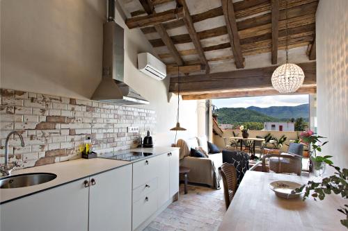 a kitchen and living room with a counter and a table at El Jardinet de Sant Esteve in Olot