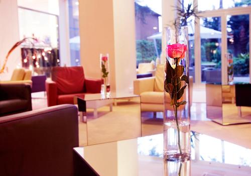 a vase with a rose sitting on a table in a lobby at Hotel Mioni Royal San in Montegrotto Terme