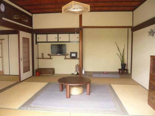 een kamer met een tafel in het midden van een kamer bij Kitamineyama Gotsuan in Kimino