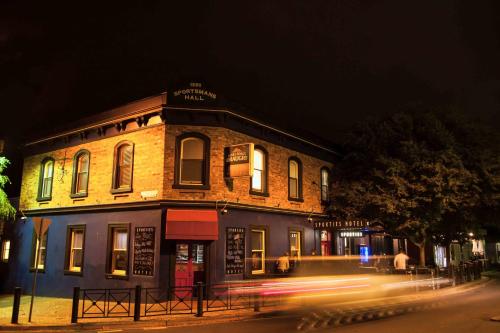 a building on the corner of a street at night at Sporties Hotel in Launceston