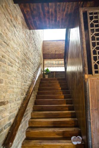 a staircase in a building with a brick wall at Rural House in Yangshuo
