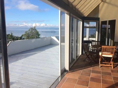 a balcony with a view of the ocean from a house at Harbour Lodge Wellington in Wellington