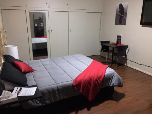 een slaapkamer met een bed met een rode deken erop bij Edward River Hotel in Deniliquin