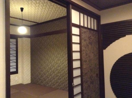 a room with a glass door and a ceiling at Guest House Kuranomachi ゲストハウス蔵の街 in Tochigi