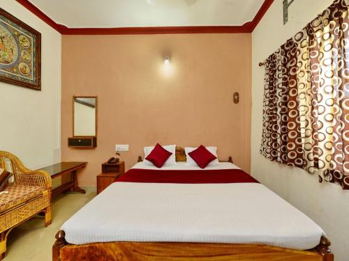 a bedroom with a large bed with red pillows at Surya Inn in Konārka