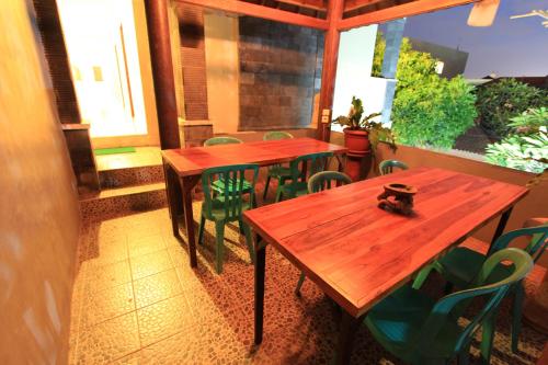 2 mesas de madera en un restaurante con sillas verdes en Surya Inn, en Kuta