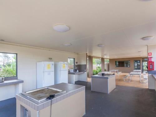 a large kitchen with white appliances in a room at NRMA Eastern Beach Holiday Park in Lakes Entrance