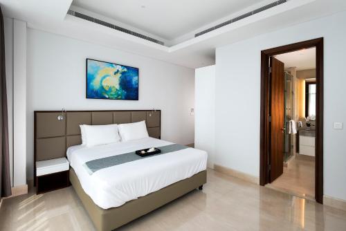 Oakwood Suites La Maison Jakarta tesisinde bir odada yatak veya yataklar