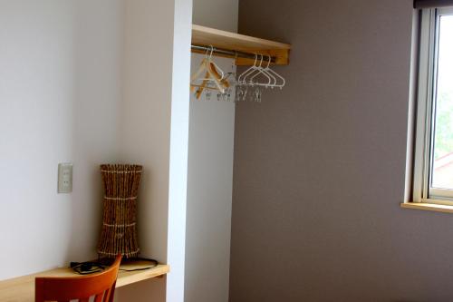 a room with a closet with a desk and a window at Niseko Guesthouse Nalu. in Niseko