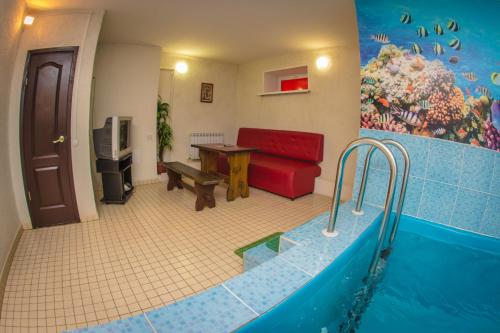 sala de estar con sofá rojo y bañera en Aura Hotel-ZURO, en Ulyanovsk