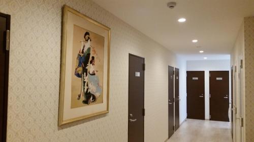 a painting of a woman on a wall in a hallway at Tokyo Guest House 2020 in Tokyo