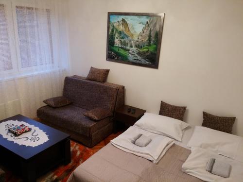 ein Wohnzimmer mit einem Sofa und einem Stuhl in der Unterkunft Apartman Sutjeska in Tjentište