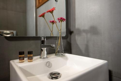 a bathroom sink with a vase of flowers on it at Panorama Studios in Ierissos