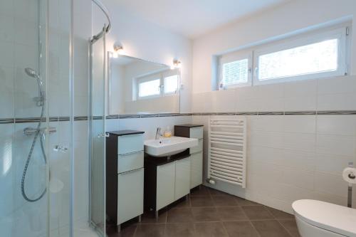 Un baño blanco con lavabo y ducha. en Apartments Patricia, en Bled