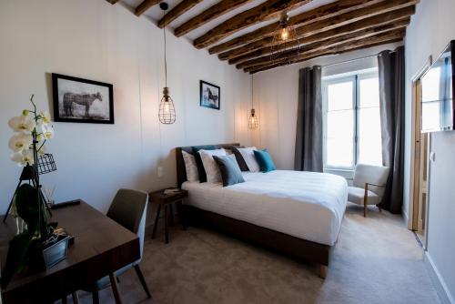 Un pat sau paturi într-o cameră la Hôtel Le Chantilly