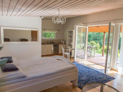 a bedroom with a bed and a kitchen with a patio at Domek w Dolinie Drwęcy in Lubicz