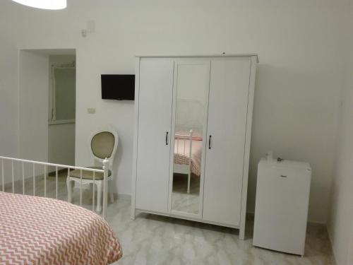 a bedroom with a white cabinet next to a bed at B&B L'Antico Ortale in Carovigno