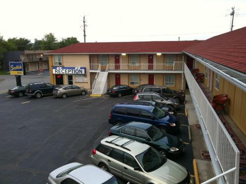 a row of cars parked in a parking lot in front of a hotel at Scottish Inn Near the Falls and Casino in Niagara Falls