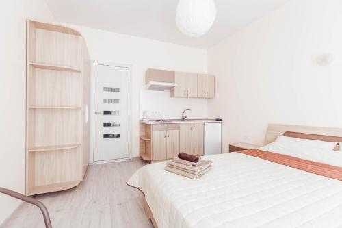 a white bedroom with a bed and a sink at Apartments near Deribasovskaya in Odesa