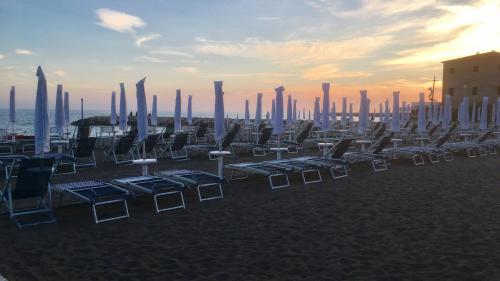 a group of chairs and tables in front of a city at Lungomare Hotel in Marina di Cecina