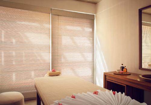 a bedroom with a bed and a window with blinds at Jetwing Blue in Negombo