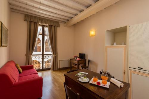 - un salon avec un canapé rouge et une table dans l'établissement Relais Palazzo Paleologi Sec.XIV, à Lu