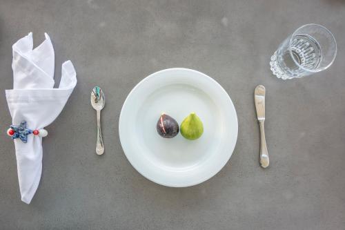 a white plate with a green pear on a table with spoons at Passos Villas in Parasporos