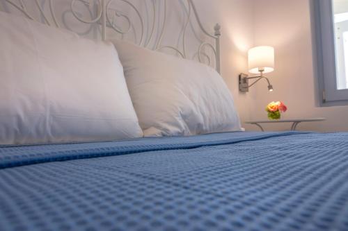 a bed with a blue comforter and a white pillow at Passos Villas in Parasporos