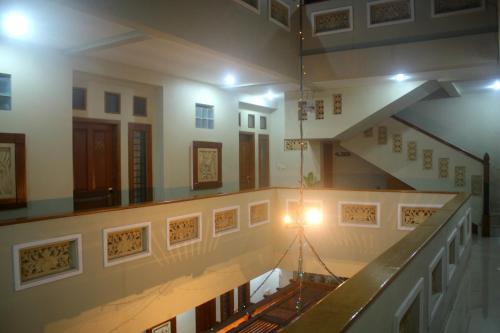 a hallway with a staircase in a building with a light at Hotel Mataram 2 Malioboro in Yogyakarta