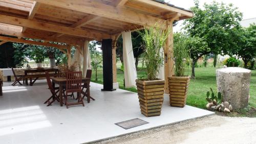 a wooden pergola with a table and chairs under it at "L'Ancienne Etable" Dordogne in Saint-Avit-Saint-Nazaire