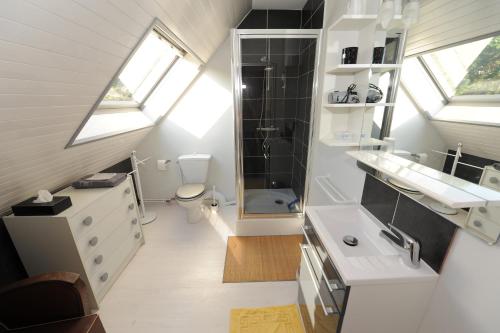 a white bathroom with a sink and a toilet at Aux doux Becots - Bed & Breakfast in Hardelot-Plage
