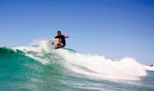a man riding a wave on a surfboard in the ocean at Coolangatta Sands Hotel in Gold Coast
