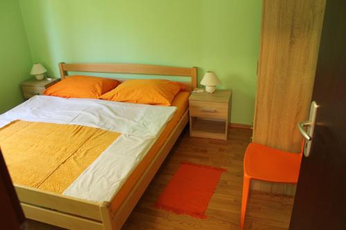a bedroom with a bed with orange pillows on it at Apartment Ruby in Mandre