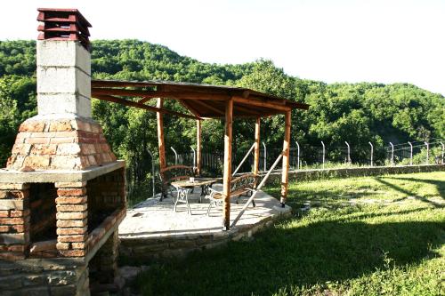 a patio with a table and chairs and a fireplace at Guesthouse Alexandros in Nestorio