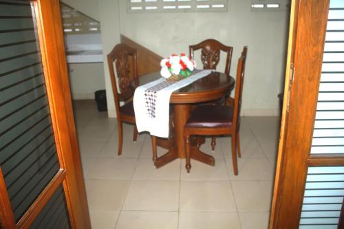 a dining room table and chairs with a cake on it at Hotel Mataram 2 Malioboro in Yogyakarta