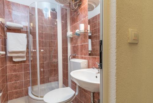 a bathroom with a toilet sink and a shower at Villa Marija in Trogir