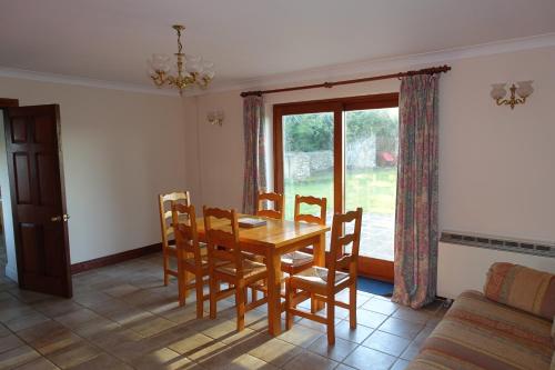 a dining room with a table and chairs and a window at Tyddyn Crwn Country-House Apartments in Beaumaris