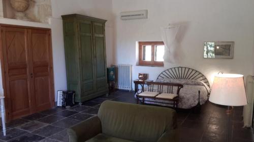 a bedroom with a bed and a chair and a lamp at Case Brizza in Casale Zappulla