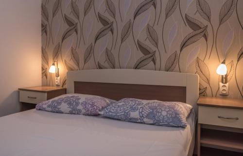 a bedroom with a bed with two tables and two pillows at Villa Marija in Trogir