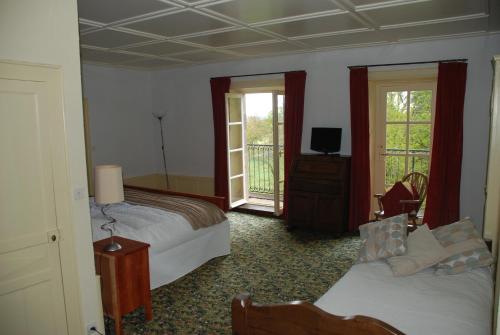 ein Hotelzimmer mit 2 Betten und einem TV in der Unterkunft B&B Chateau le Bois in Saint-Julien-aux-Bois