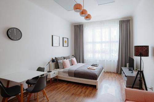 a bedroom with a bed and a table and chairs at Apartment Gesse Jirsikova in Prague