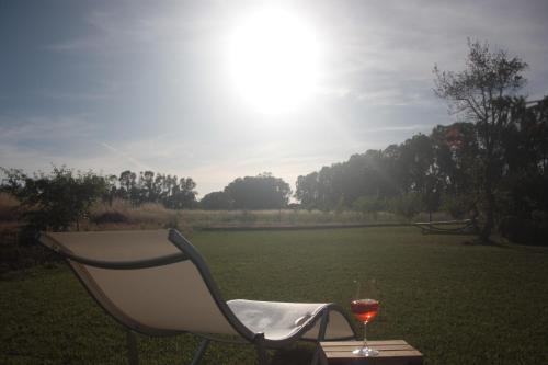 a chair and a glass of wine on a table at Villa Arzilla Sardegna in Alghero