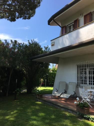 two chairs sitting on a porch of a house at Holiday home Villetta Cinquale in Cinquale