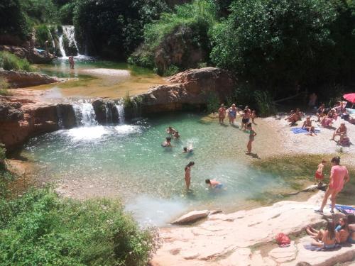 a group of people in the water at a waterfall at Apartamentos Can Juver in Beceite