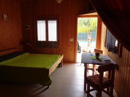 1 dormitorio con cama, mesa y ventana en Bungalow Janet, en Cassibile