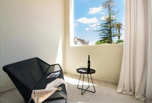 a room with a chair and a table and a window at Bordoy Casa Ládico - Hotel Boutique Adults Only in Mahón