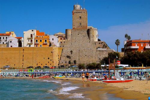a beach with a building and a clock tower at La casa di Michela in Termoli