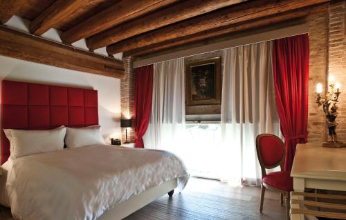 a bedroom with a large bed and a red headboard at La Barchessa di Villa Pisani in Lonigo